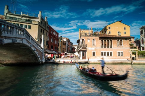 Ancient buildings and boats in the channel in Venice