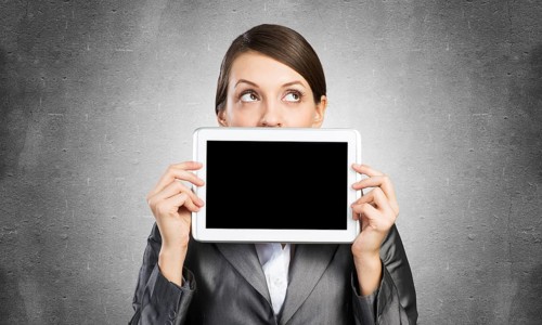 Businesswoman holding tablet computer with blank screen. Beautiful woman in business suit show