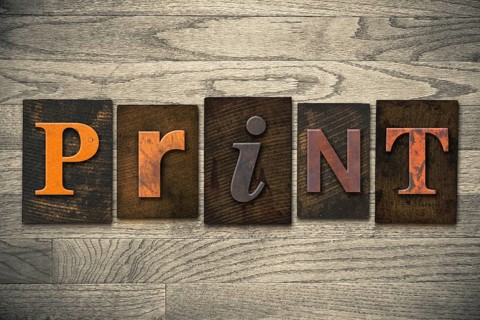 The word PRINT written in wooden letterpress type