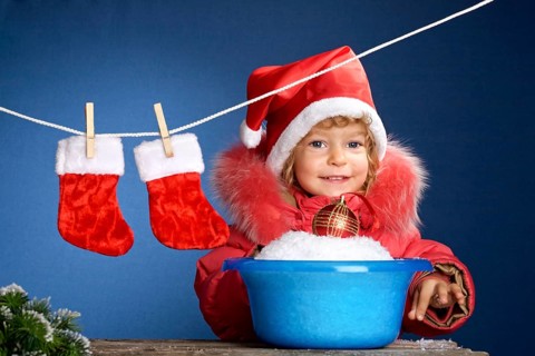 Child in Santa hat washing in basin. Christmas concept