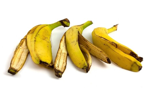 Three peels from bananas that begin to rot. Organic fruit waste isolated on white background