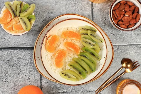 Healthy breakfast with ingredients, Rice pudding with kiwi, honey, tangerines and almonds.flat lay,