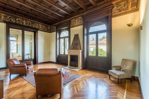 Interior of an ancient luxury house. Decorated wooden ceiling. Elegant fireplace. Living room