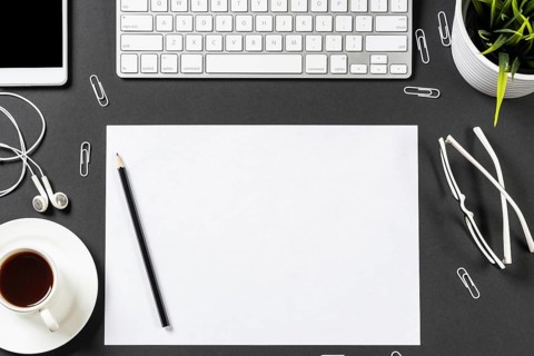Top view of modern workplace with blank paper sheet. Flat lay black surface with smartphone,
