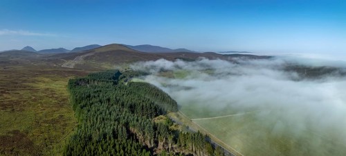 Coastal fog in the Scottish Highlands with hills, in the background prominent peak of Morven,