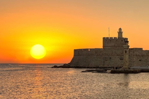 The sunrise at the entrance with the deers of the old port of Rhodes, Greece