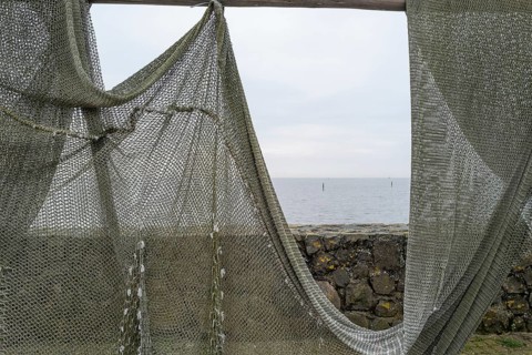 Fishing nets to dry on the road by the sea