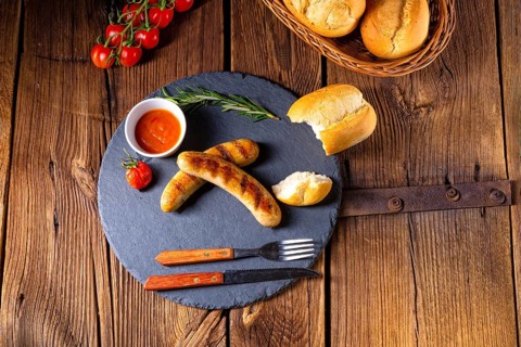 Rustic bratwurst with ketchup and fresh rolls