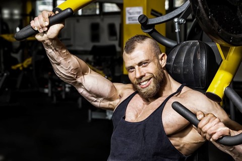 An image of a handsome bearded bodybuilding man doing chest workout