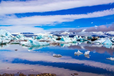 Clouds reflected in the smooth water of the largest glacial lagoon Jokulsaurloun. Iceland. Cold