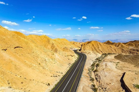 Israel. Desert on the shores of the Dead Sea. Asphalt highway meanders among the hills. Dead Sea