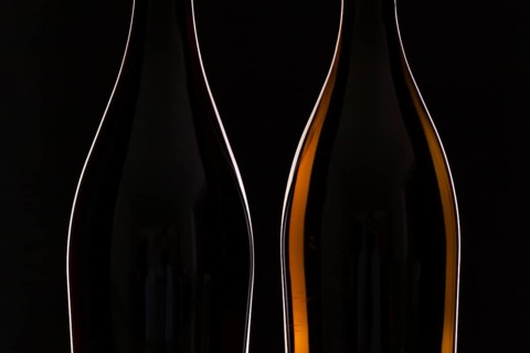 Two different bottles of wine on the black background