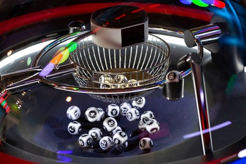 Black and white lottery balls in a rotating bingo machine. Lottery balls in a sphere in motion.