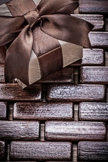 Wrapped giftbox on wooden wicker matting holidays concept