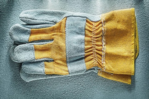 Pair of safety gloves on concrete background