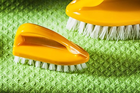 Set of new plastic brushes on green dishcloth