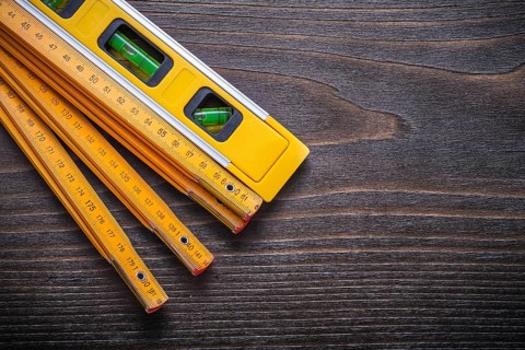Set of yellow construction level with wooden meter on vintage wood board maintenance concept