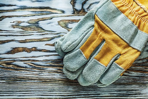 Pair of safety gloves on wooden board
