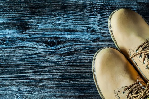 Pair of safety boots on vintage wooden board