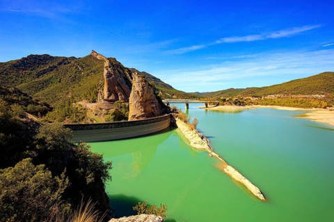 Picturesque conical rocks and a bridge over the reservoir. Magnificent dam collects the water of