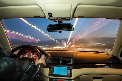Car interior on driving. Blurred night lights