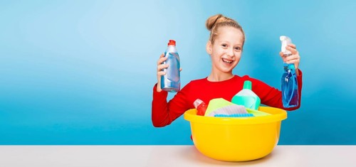 Isolated on blue, cheerful girl in red pullover with fair-haired updo, holding in both hands a