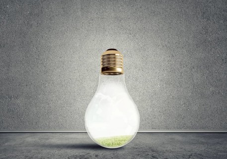 Glass light bulb in concrete empty room. Eco concept