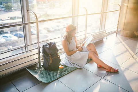 Waiting, delayed transport in the terminal of the airport or train station. Young caucasian woman
