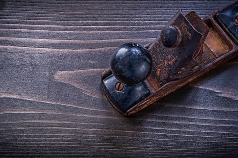 Vintage grunge planer on wooden board construction concept