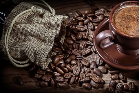 Poured beans from sack and clay coffee cup