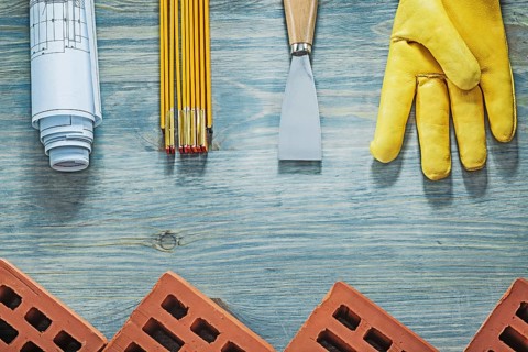 Assortment of bricklaying tools on wooden board building concept