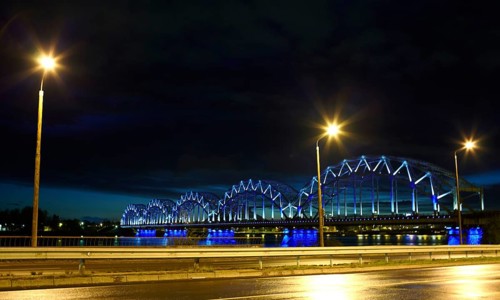 Railway bridge at night with citylights and dark sky