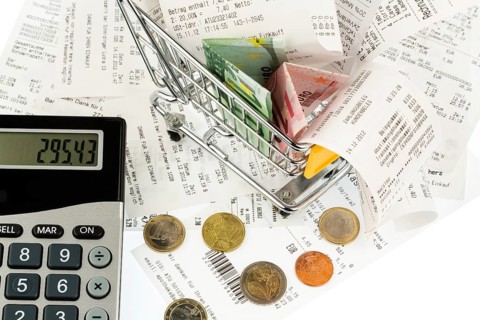 Shopping trolleys, banknotes and receipts, symbolising purchasing power, consumption and inflation