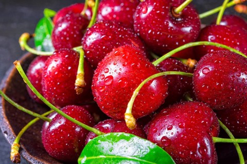 Freshly picked cherry in a wooden bowl