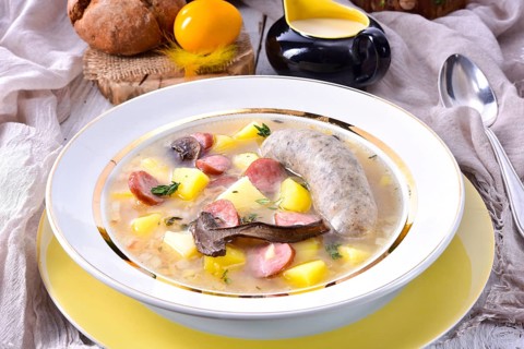 A polished Easter soup with homemade white sausages and mushrooms