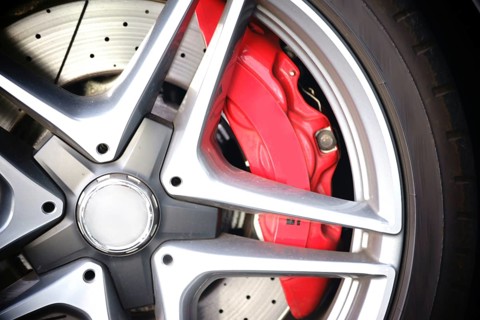 Close-up of the spoke rims of a sports car with brake discs