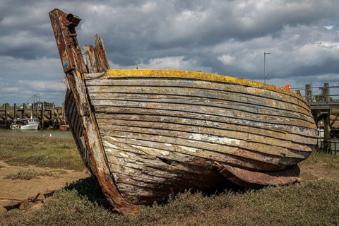 Rye Harbour, East Sussex, England, UK, May 12, 2022: An old shipwreck and some boats on the banks