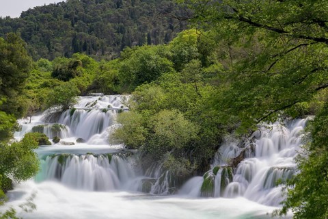Several waterfalls flow through a lushly wooded hilly landscape, Krka Krka Waterfalls National