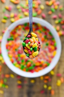 Spoon with colorful rice in the milk with blured background. Selective focus