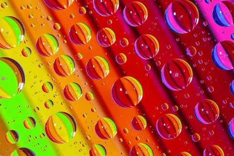 Color pencils under glass with drops of water. Office concept