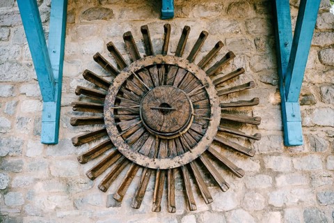 The wheel of a water mill. The old wooden wheel of the water mill is used as an element of decor on