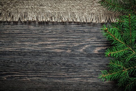 Vintage sackcloth pine branch on wooden board Christmas background