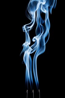 Delicate smoke plumes, puffs and eddies from burning incense sticks