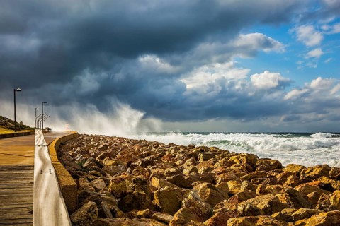 The storm in the Mediterranean Sea. Huge foaming waves beating against the shore. New Quay in the