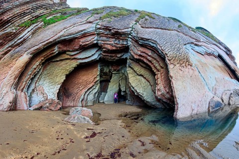 Picturesque huge cave on the beach. Low tide in the Atlantic. Flysch - unique landscape of