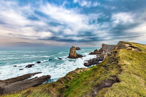 Portio beach. Rocky coastline of the Atlantic Ocean. Spanish coast, Cantabria. Stormy autumn day in