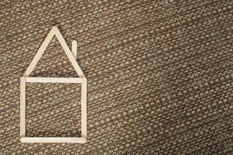 Model house made of wooden sticks placed in room interior