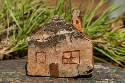 Model of a small wooden house. Green natural background