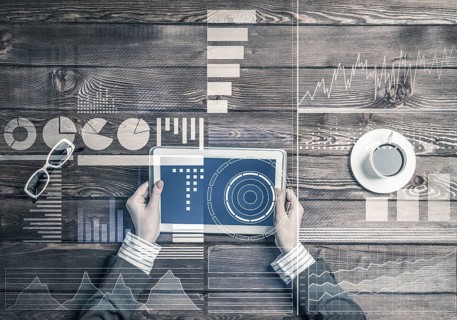 Business workplace with tablet device on wooden surface and media interface