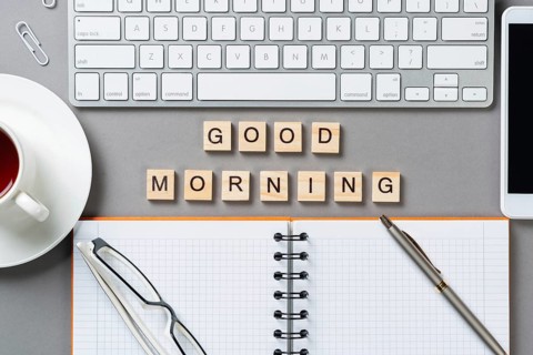 Good morning message with letters on wooden cubes. Still life of workspace with supplies. Flat lay